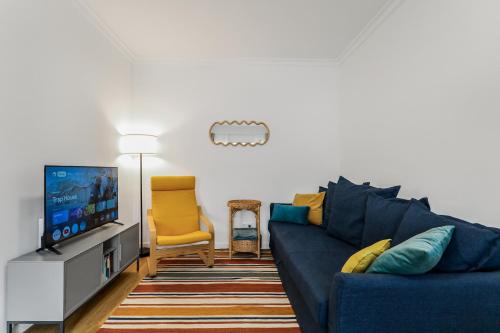 a living room with a blue couch and a tv at VV Gara Galdar in Gáldar