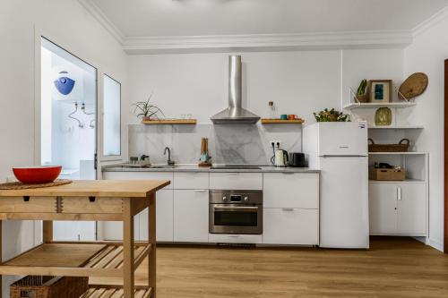 a kitchen with white appliances and a wooden table at VV Gara Galdar in Gáldar