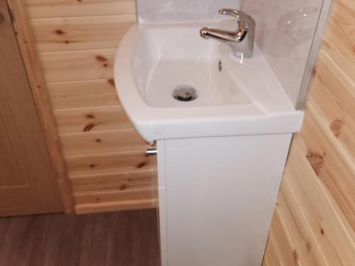 a white sink in a bathroom with a wooden floor at Lodge 3 in Llanelli