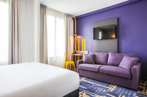 a purple room with a bed and a couch at ibis Styles Paris Mairie De Clichy in Clichy