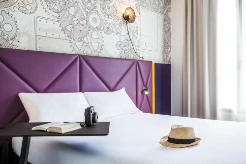 a bedroom with a bed with a hat on a table at ibis Styles Paris Mairie De Clichy in Clichy