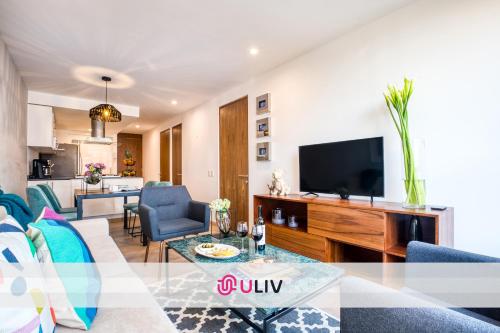 a living room with a couch and a tv at ULIV Polanco in Mexico City