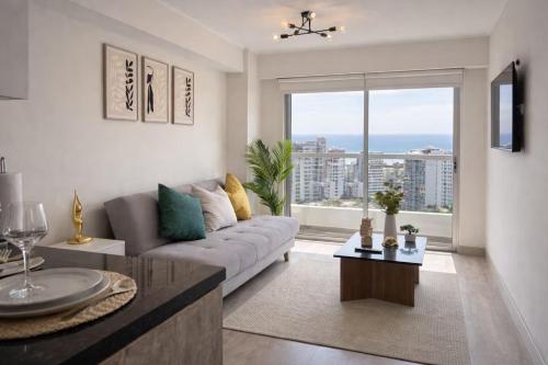 a living room with a couch and a large window at G15 Apartments by Vibrant in Lima
