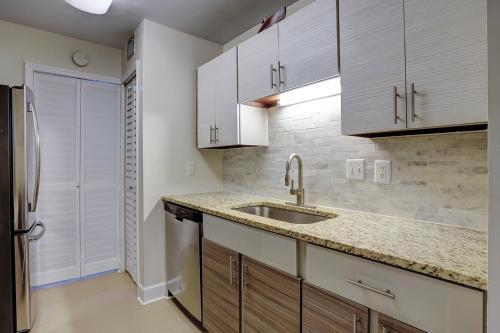 a kitchen with white cabinets and a sink and a refrigerator at Clipper Court 814 in Hilton Head Island