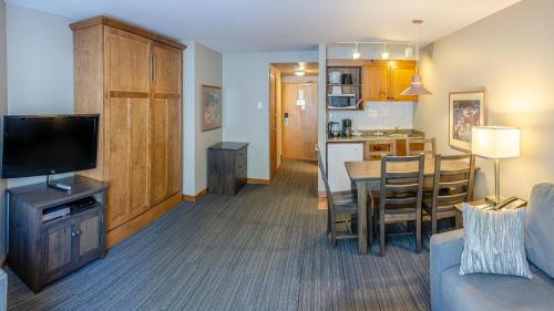 a living room with a couch and a table and a kitchen at Cahilty #231 home in Sun Peaks