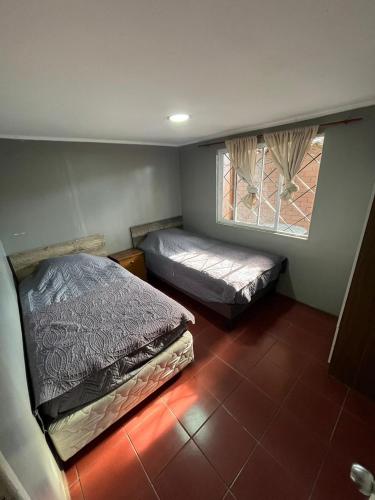 a bedroom with two beds and a window at Hostal JV CASA AMPLIA in Nogales