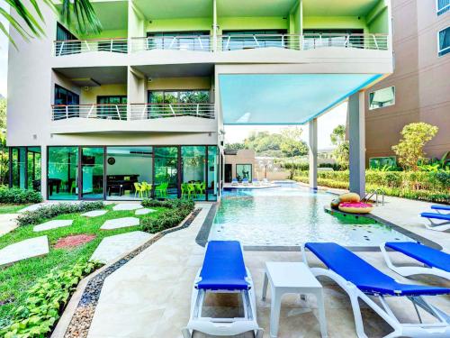 a house with a swimming pool and blue chairs at Splendid Hotel @ Khaoyai in Mu Si