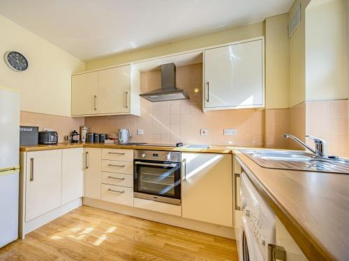 a kitchen with white cabinets and a sink at 1 Bed in Cockermouth oc-87480 in Cockermouth