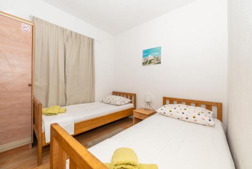 a bedroom with two beds and a window at Holiday house Marijana in Zagvozd