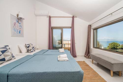 a bedroom with a blue bed and a large window at Astarte Villas - Casa De Sun Private Villa with Pool in Zakynthos