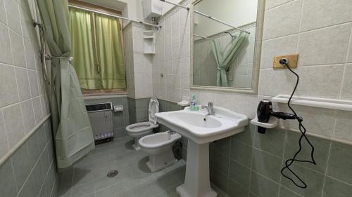 a bathroom with a sink and a toilet and a mirror at La Mola B&B in Vignanello