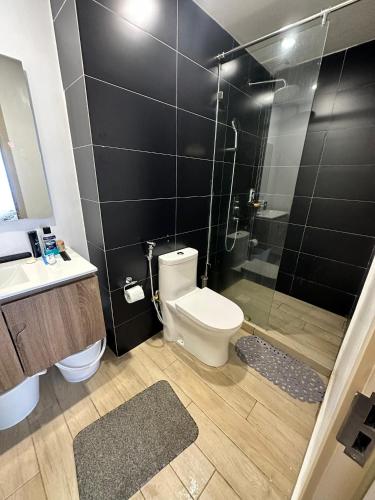 a bathroom with a shower and a toilet and a sink at BlaQ Homes in Kanga