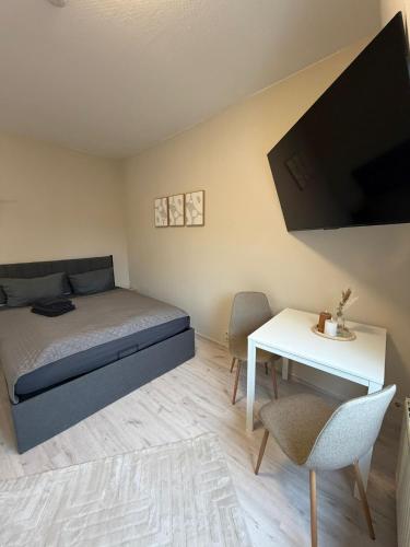 a bedroom with a bed and a desk and a tv at SchaeBu! 7 Apartment Work and Travel am Altmarkt in Cottbus