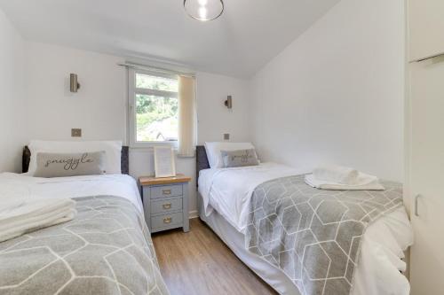 a bedroom with two beds and a window at 2 Bed in Caswell Bay oc-hh379 in Newton