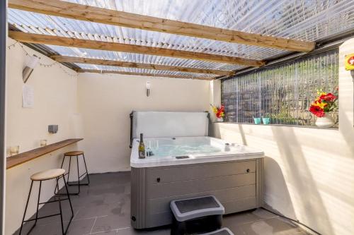 a bathroom with a tub and two stools and a window at 2 Bed in Lixwm oc-bow179 in Halkyn