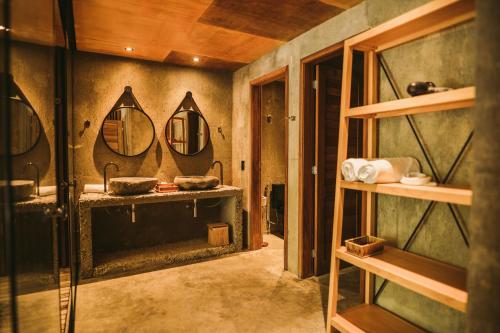 a bathroom with two sinks and a mirror at Pedras Do Patacho Hotel Boutique Experience in Pôrto de Pedras