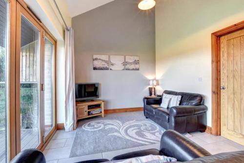a living room with a leather couch and a television at 2 Bed in Cardiff oc-91710 in Cardiff