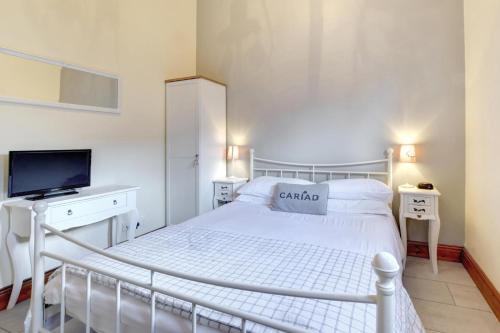 a white bedroom with a white bed and a tv at 2 Bed in Cardiff oc-91710 in Cardiff