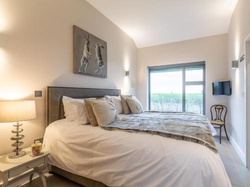 a bedroom with a large white bed with a window at 2 Bed in Diss oc-51468 in Wortham
