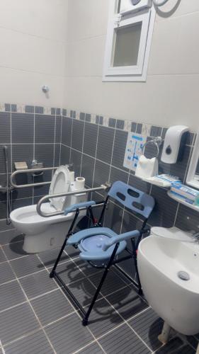 a bathroom with two toilets and a sink at Najmat Sabbabah Furnished Units in Hail