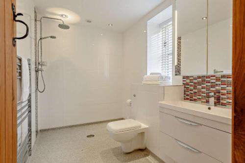 a white bathroom with a toilet and a shower at 2 Bed in Gilwern oc-o27004 in Gilwern