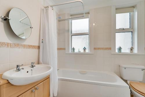 a bathroom with a sink and a tub and a mirror at 2 Bed in Seaton oc-mbbri in Seaton