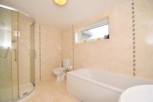 a bathroom with a tub and a toilet and a sink at 4 Bed in Seaton oc-s27403 in Seaton