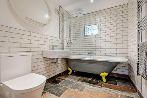 a bathroom with a tub and a toilet and a sink at 1 Bed in Werrington oc-c29073 in Werrington