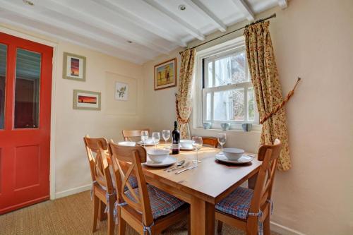 a dining room with a wooden table and a red door at 3 Bed in Little Walsingham oc-1386 in Little Walsingham