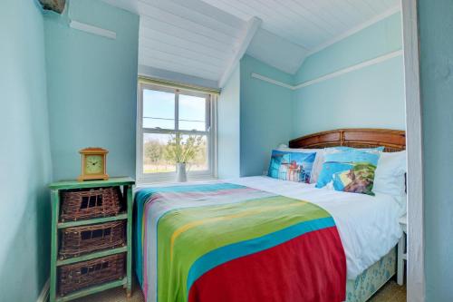 a bedroom with a colorful bed and a window at 3 Bed in Little Walsingham oc-1386 in Little Walsingham