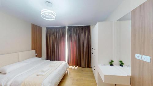 una camera da letto bianca con un letto grande e un lavandino di Vila MUJE a Belsh