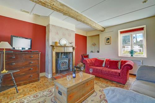 a living room with a red couch and a fireplace at 3 Bed in Little Walsingham oc-1386 in Little Walsingham