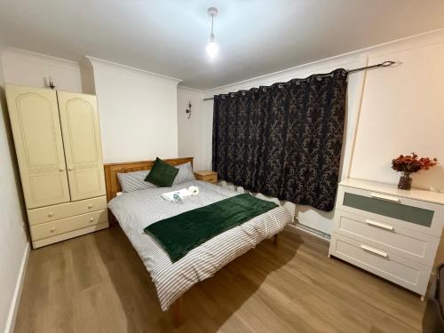 a small bedroom with a bed and a window at Exquisite King-sized Bedroom - Free Parking in Dartford