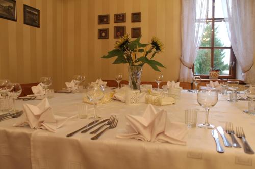 a table with a white table cloth and a vase with flowers at Svečių namai Lingės in Nemėžis