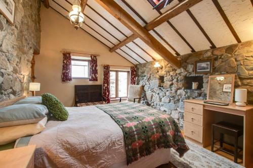 a bedroom with a bed and a stone wall at 2 Bed in Caernarfon oc-wag263 in Llandegfan