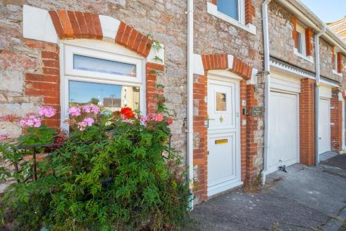 a brick house with a white door and flowers at 2 Bed in Torquay oc-sdmarg in Torquay