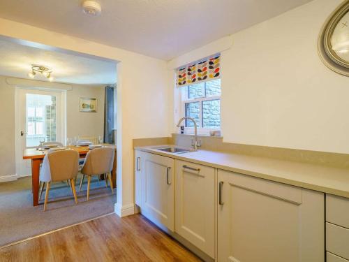 a kitchen with a sink and a table with chairs at 2 Bed in Sedbergh oc-89266 in Milnthorpe