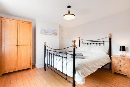 a bedroom with a black bed and a wooden cabinet at 3 Bed in Docking oc-1837 in Docking