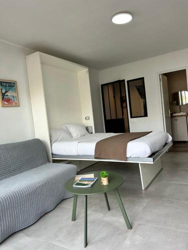 a bedroom with a bed and a couch and a table at Studio face plage / centre ville in Arcachon