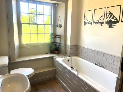 a bathroom with a tub and a toilet and a sink at 2 Bed in Cockermouth oc-86023 in Lorton