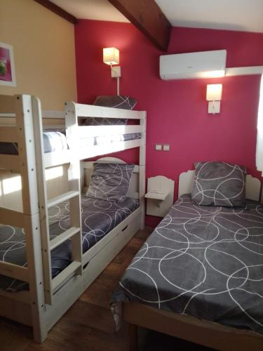 two bunk beds in a room with red walls at RESIDENCE du NEPTUNE in Saint-Cyprien-Plage