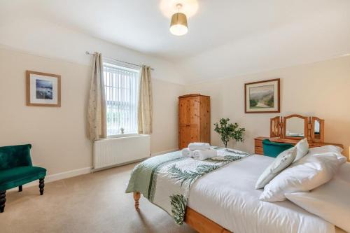 a bedroom with a large bed and a green chair at 2 Bed in Berwick-upon-Tweed oc-l32027 in Kyloe