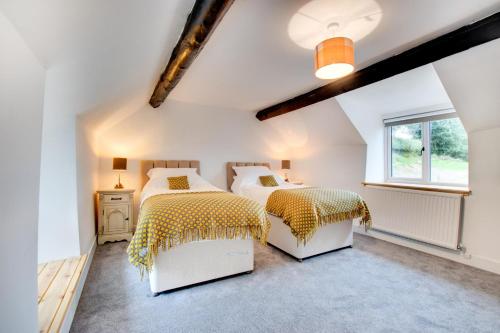 a bedroom with two beds and a window at 4 Bed in Ruthin oc-bow136 in Gwyddelwern