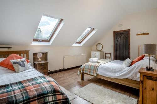 a attic bedroom with two beds and skylights at 2 Bed in Trallong oc-bow106 in Sennybridge
