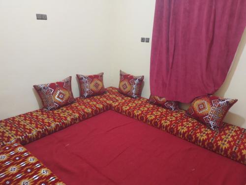 a couch with colorful pillows and a curtain at Chez zakaria guest house in Merzouga