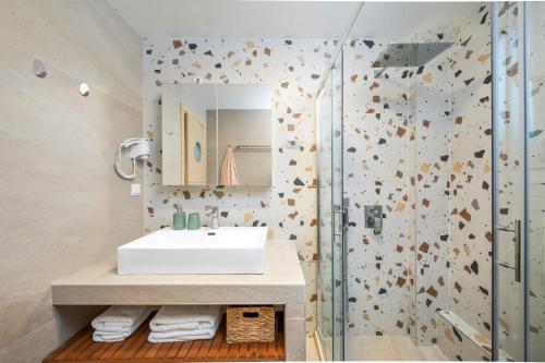 a bathroom with a sink and a shower at Thalia by Vintage Travel in Agios Georgios