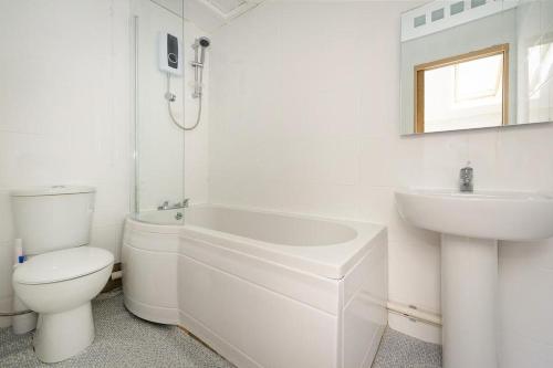 a white bathroom with a toilet and a sink at 2 Bed in Pwllheli oc-glanab in Abersoch