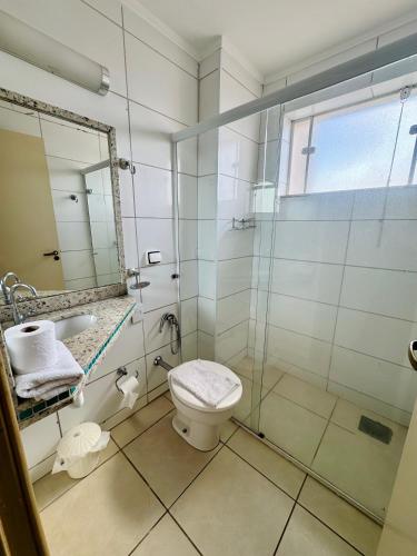 a bathroom with a shower and a toilet and a sink at Copaiba Palace Hotel in Bauru