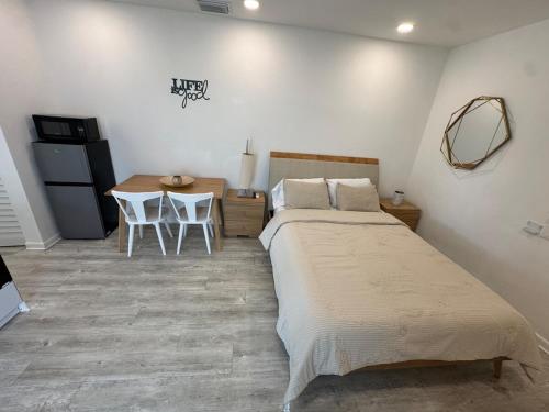 a bedroom with a bed and a table with chairs at Central location in Cutler Bay