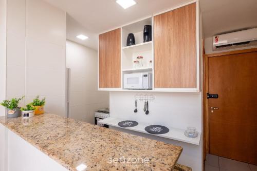 a kitchen with a counter top and a microwave at Studio w/ pool & barbecue in the building RAQ1609 in Salvador